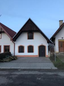ein weißes Haus mit einer großen Einfahrt davor in der Unterkunft Vinný sklep v Zarazicích in Veselí nad Moravou