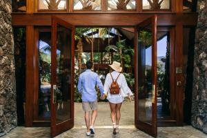 un homme et une femme marchant par une porte dans l'établissement Catamaran Resort Hotel and Spa, à San Diego