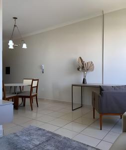 uma sala de estar com uma mesa e uma sala de jantar em Apartamento no Centro! em Franca