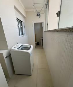 a bathroom with a toilet in the middle of a room at Apartamento no Centro! in Franca