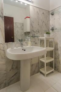 a white sink in a bathroom with marble walls at Casa da Praia in Luz +25 photos