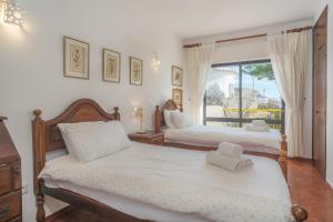1 Schlafzimmer mit 2 Betten und einem Fenster in der Unterkunft Casa da Praia in Luz