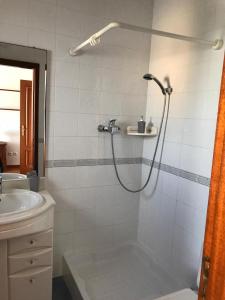 uma casa de banho com um chuveiro e um lavatório. em The South Sunny House - A Casa a Sul em Olhão