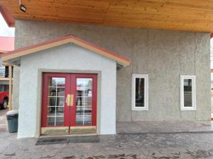 budynek z czerwonymi drzwiami i drewnianym dachem w obiekcie Econo Lodge w mieście Springerville