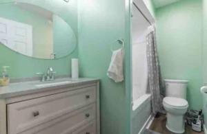 y baño con lavabo, aseo y espejo. en Riverfront Suites, Quinte, ON, en Frankford