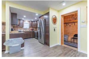 eine große Küche mit Holzschränken und einem Kühlschrank in der Unterkunft Riverfront Suites, Quinte, ON in Frankford