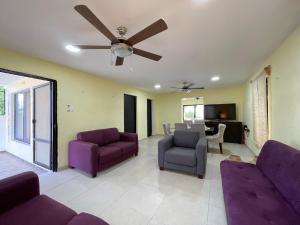 sala de estar con muebles de color púrpura y ventilador de techo en LELÁA A NAJ, en Mérida