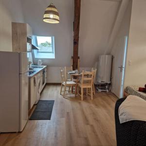 een keuken en eetkamer met een tafel en stoelen bij Joli studio - proche de Chambord in Mer