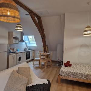 een woonkamer met een bank en een tafel in een keuken bij Joli studio - proche de Chambord in Mer