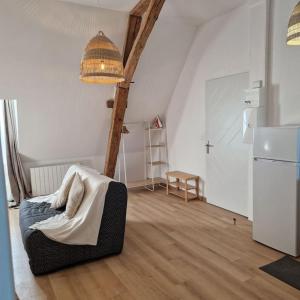 een woonkamer met een bed en een koelkast bij Joli studio - proche de Chambord in Mer