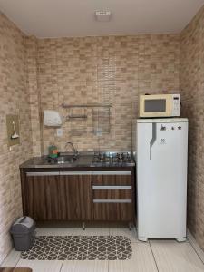 uma cozinha com um frigorífico branco e um micro-ondas em Studio25_Apto região central Foz em Foz do Iguaçu