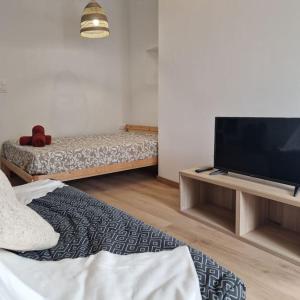een woonkamer met een bank en een flatscreen-tv bij Joli studio - proche de Chambord in Mer