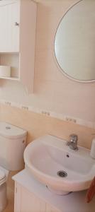 uma casa de banho branca com um lavatório e um espelho em La belleza del Tietar em Lanzahita