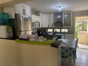 a kitchen with white cabinets and a green counter top at Casa para alugar in Aquiraz
