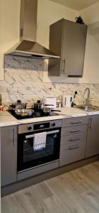a kitchen with a stove and a sink at SuperValue Suite 10 - Fast WiFi, Hotel Linen, Keyless Entry, City only 10 Mins - BY PROPERTY PROMISE in Cardiff