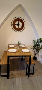 a wooden table with glasses and a clock on the wall at SuperValue Suite 10 - Fast WiFi, Hotel Linen, Keyless Entry, City only 10 Mins - BY PROPERTY PROMISE in Cardiff