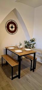 a wooden table with glasses and a clock on the wall at SuperValue Suite 10 - Fast WiFi, Hotel Linen, Keyless Entry, City only 10 Mins - BY PROPERTY PROMISE in Cardiff