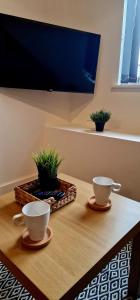 two coffee cups sitting on a table with plants at SuperValue Suite 10 - Fast WiFi, Hotel Linen, Keyless Entry, City only 10 Mins - BY PROPERTY PROMISE in Cardiff