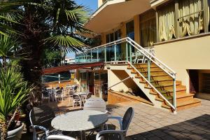 een patio met een tafel en stoelen en een trap bij Hotel Bamar in Cervia