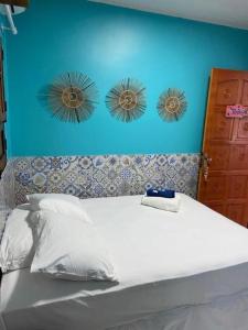 een bed met drie spiegels op een blauwe muur bij Pousada Vila Milagres in São Miguel dos Milagres