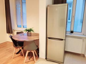 a refrigerator in a kitchen next to a table at Floridsdorfer Apartment - Free Highspeed-Internet in Vienna