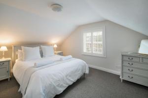 考斯的住宿－Crossjack Cottage，白色的卧室设有床和窗户