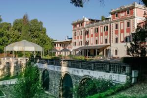 a bridge over a river in front of a building at Park Hotel Villa Potenziani in Rieti