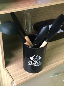 a black cup of utensils sitting on a shelf at Apartamento Natureza Verde Manauara in Manaus