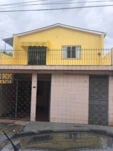 ein gelbes Haus mit Balkon darüber in der Unterkunft Apartamento Natureza Verde Manauara in Manaus