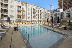 une grande piscine avec des chaises et des bâtiments dans l'établissement Global Luxury Suites at Reston, à Reston