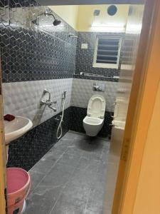 La petite salle de bains est pourvue de toilettes et d'un lavabo. dans l'établissement Chawali Family Home, à kolkata