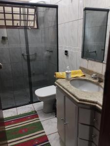 uma casa de banho com um WC, um lavatório e um chuveiro em Aero Hostel Londrina em Londrina