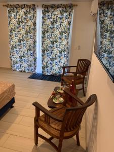 帕皮提的住宿－A TOMO MAI Homestay，客厅配有两把椅子和一张桌子