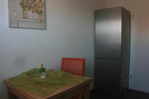 Cette chambre comprend une table, une chaise et un réfrigérateur. dans l'établissement Ferienwohnung Alpenrose, à Schwangau