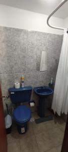 a bathroom with a blue toilet and a sink at La Plaza in Formosa