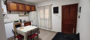 a small kitchen with a table and a refrigerator at La Plaza in Formosa