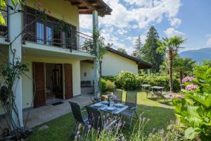 a garden with a table and chairs in front of a house at Casa Salea in Castelveccana