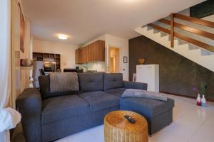 a living room with a blue couch and a kitchen at Casa Salea in Castelveccana