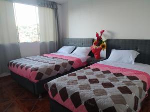- 2 lits installés l'un à côté de l'autre dans une chambre dans l'établissement HOSPEDAJE EL ARCO, à Ayacucho