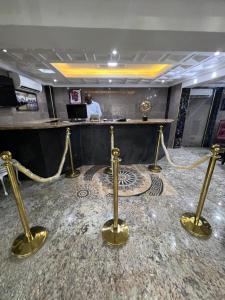 a lobby with gold barriers and a man in a desk at Ikeja Airport View in Lagos