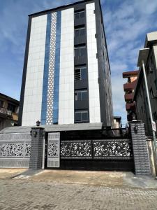 un edificio alto con una valla delante en Ikeja Airport View en Lagos