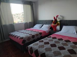 1 dormitorio con 2 camas y ventana en HOSPEDAJE EL ARCO, en Ayacucho