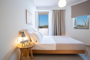 a bedroom with a bed and a table with a lamp at Lirides suites in Lefkada Town