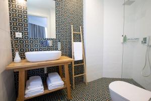 a bathroom with a sink and a shower at Lirides suites in Lefkada Town