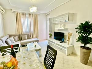 uma sala de estar com um sofá e uma mesa com uma sala de jantar em FAMILY SUITE RESIDENCE em Vlorë