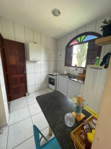 Una pequeña cocina con una mesa y una ventana. en Casa Pet Friendly, en Guarapari