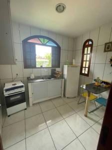 cocina con electrodomésticos blancos, ventana y mesa en Casa Pet Friendly, en Guarapari 11 fotos más