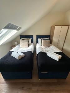 dos camas sentadas una al lado de la otra en un ático en Central Cambridge Apartments by Tas en Cambridge
