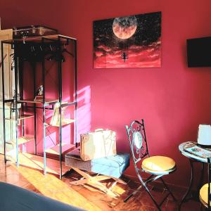 ナポリにあるNon ci resta che Napoliのピンクの壁の客室で、椅子とテーブルが備わります。