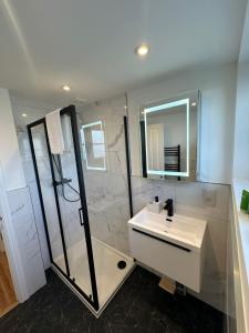 a bathroom with a sink and a shower at Central Cambridge Apartments by Tas in Cambridge